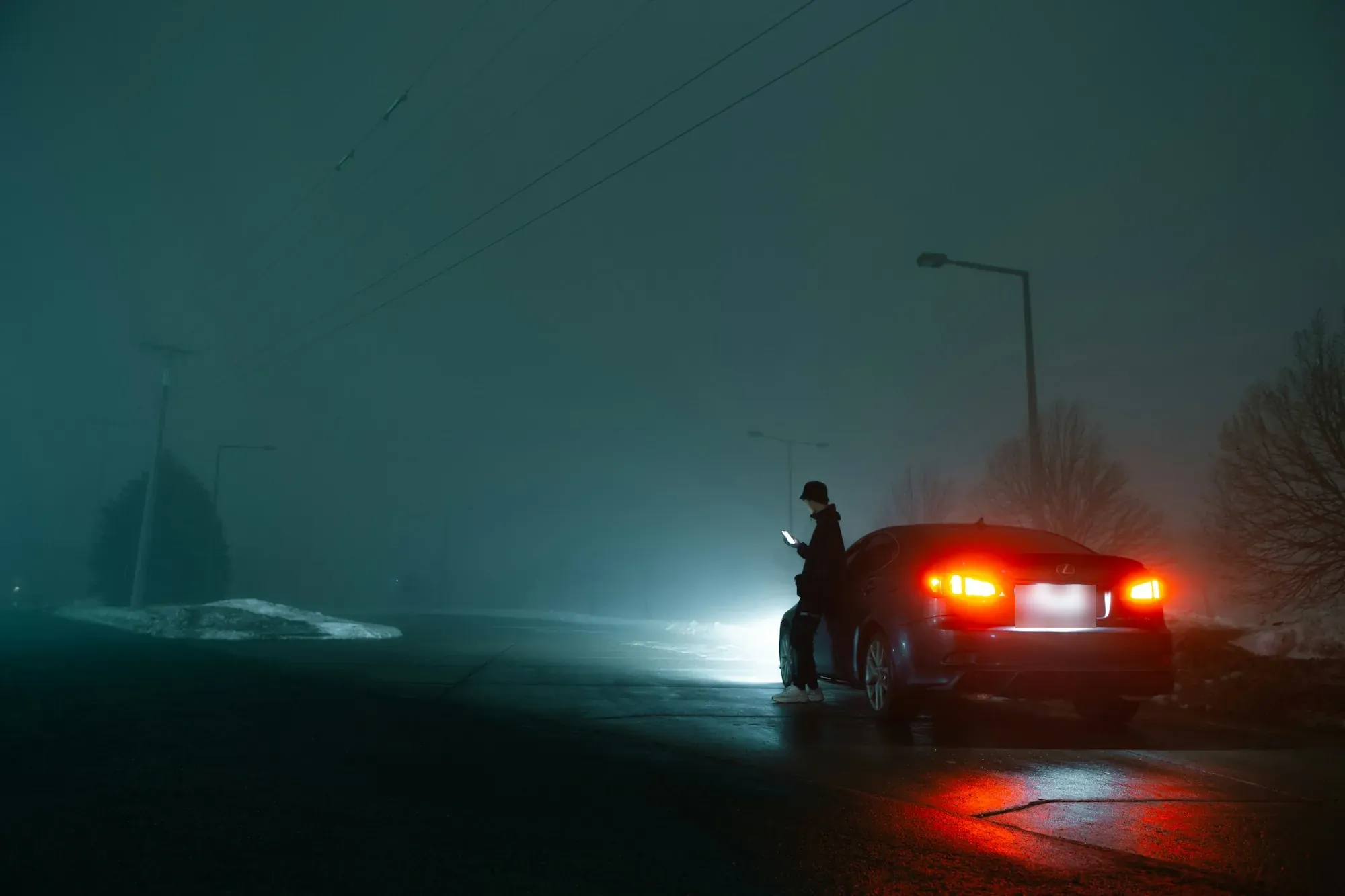 Car with hazard lights on at the roadside on a foggy night
