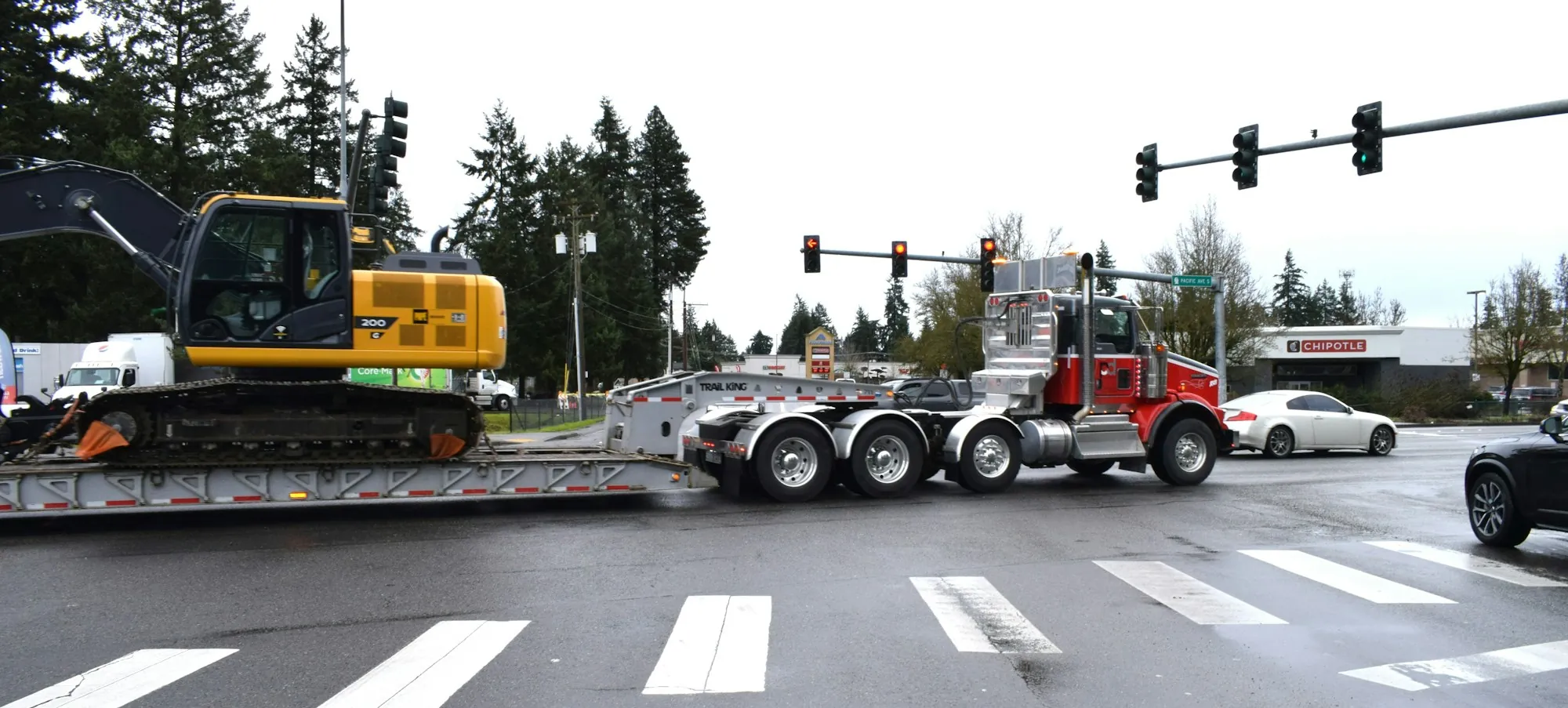 Heavy-haul truck pulling a long lowboy trailer through a city intersection